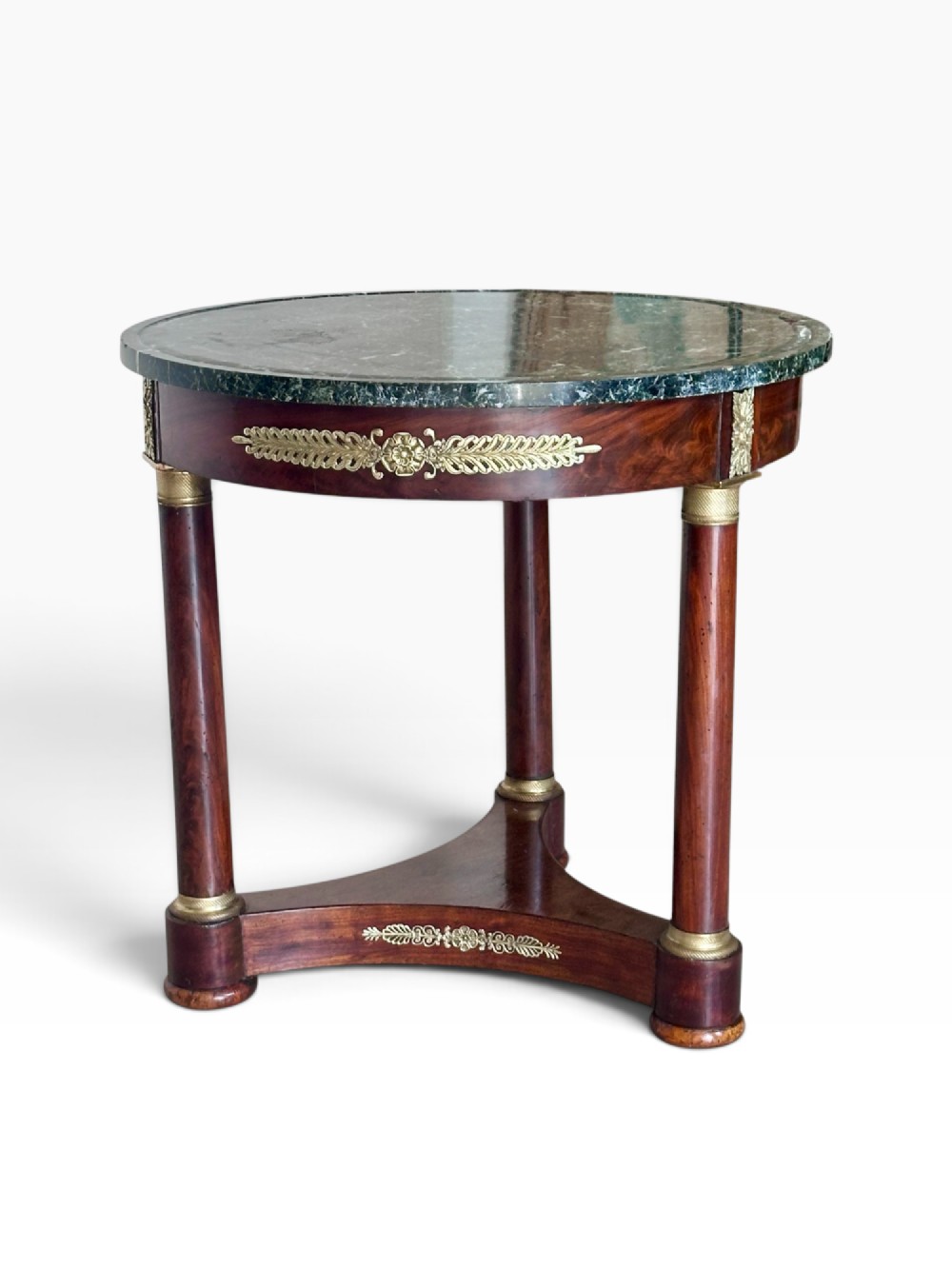 A 19th-century French Empire gueridon centre table featuring a polished circular green marble top, mahogany frame with gilded bronze mounts, three column legs, and a triform base. View II