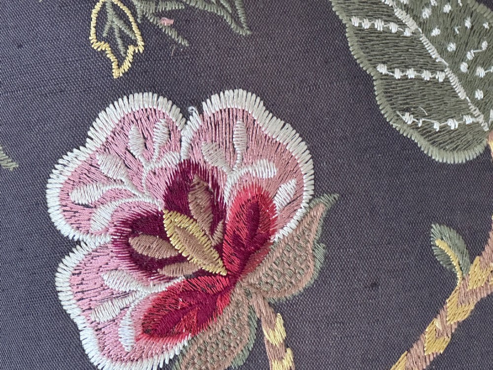 A square 19th-century William and Mary style stool featuring dark turned walnut legs, curved stretchers, and dark textile upholstery embroidered with floral motifs. View V