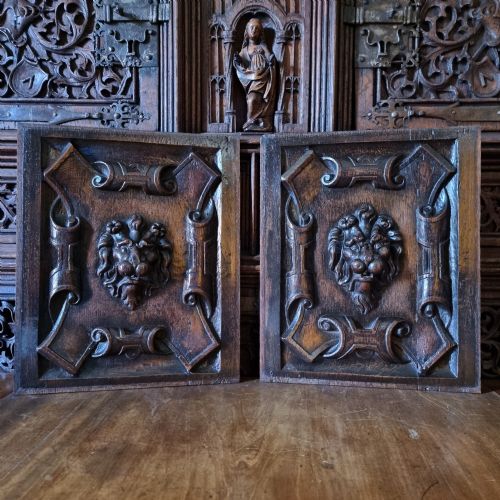 A PAIR OF 17TH CENTURY LIONS MASK PANELS