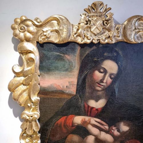 fig 2. An oil painting depicting the Madonna and Child housed in a carved gold giltwood frame with a top crest.