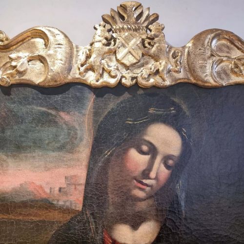 An oil painting depicting the Madonna and Child housed in a carved gold giltwood frame with a top crest. View IV