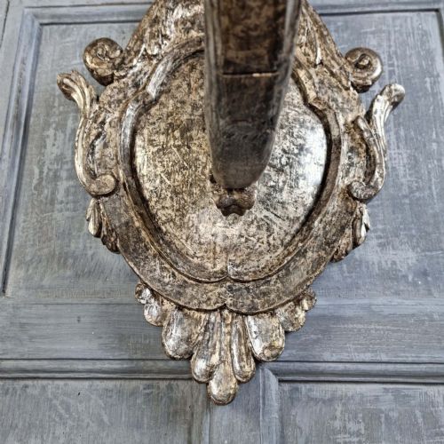 A pair of 17th-century carved wood wall sconces with silvered gilding, featuring ornate cartouche backplates, scrolling arms, and iron prickets. View XI