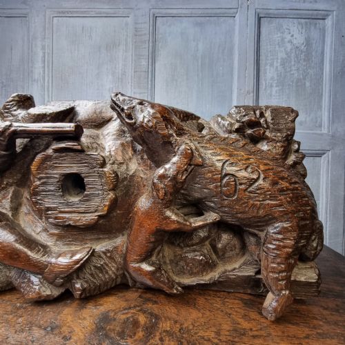 A late 17th-century carved oak relief panel depicting a hunter taking aim with a musket at a wild boar and hunting dog. View VI