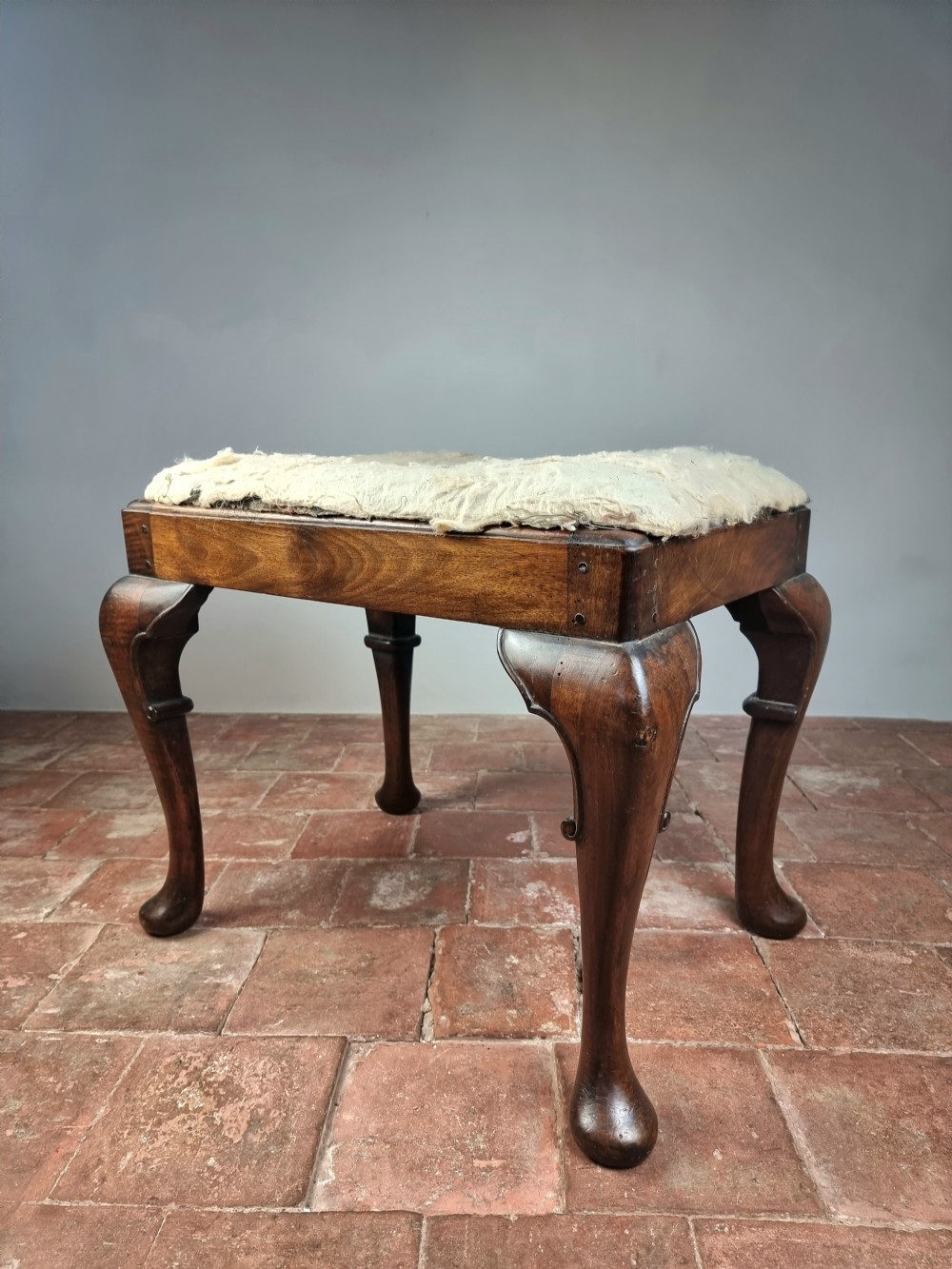 An 18th century walnut stool. 