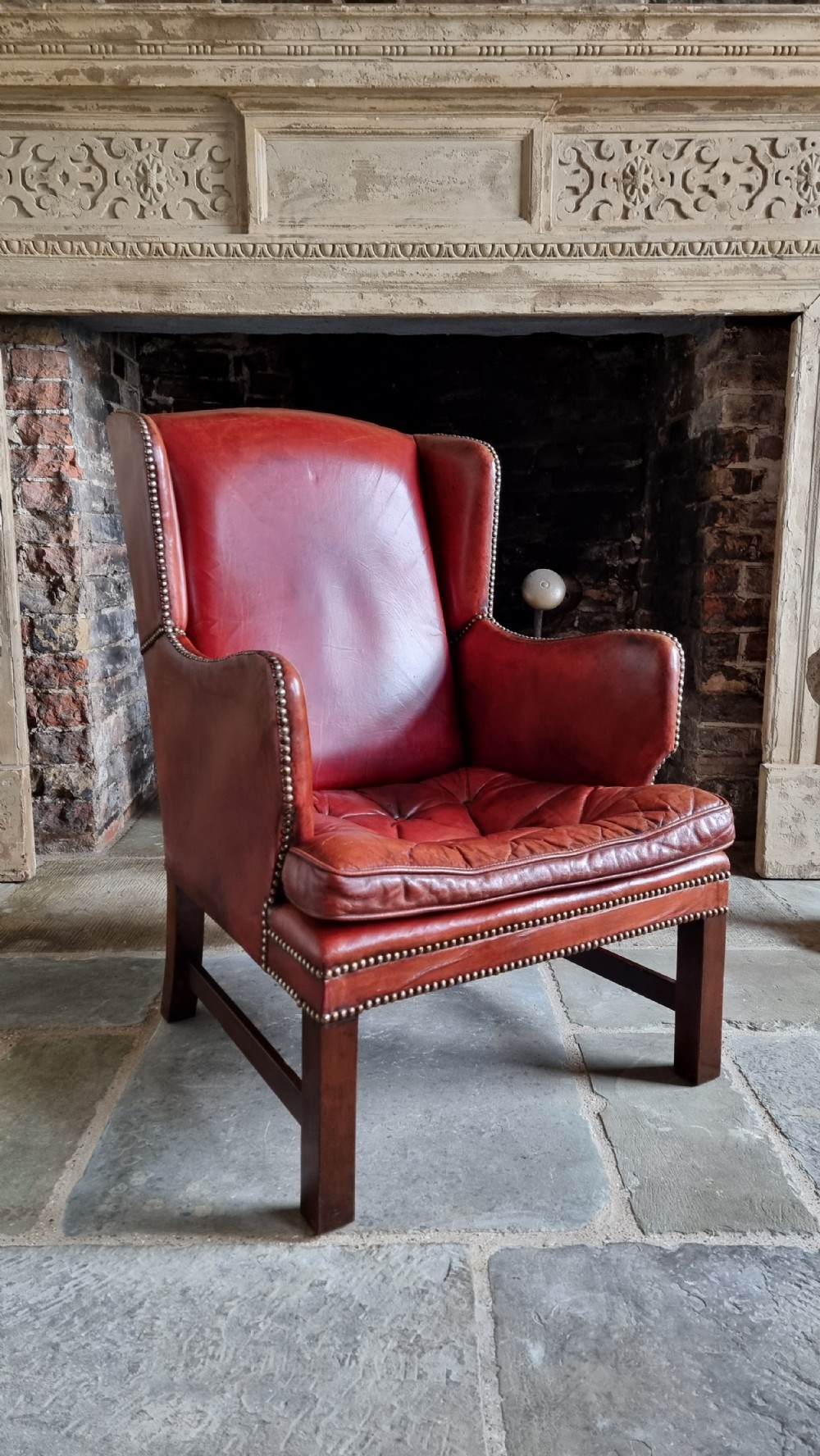 A small Georgian style leather wingchair. 