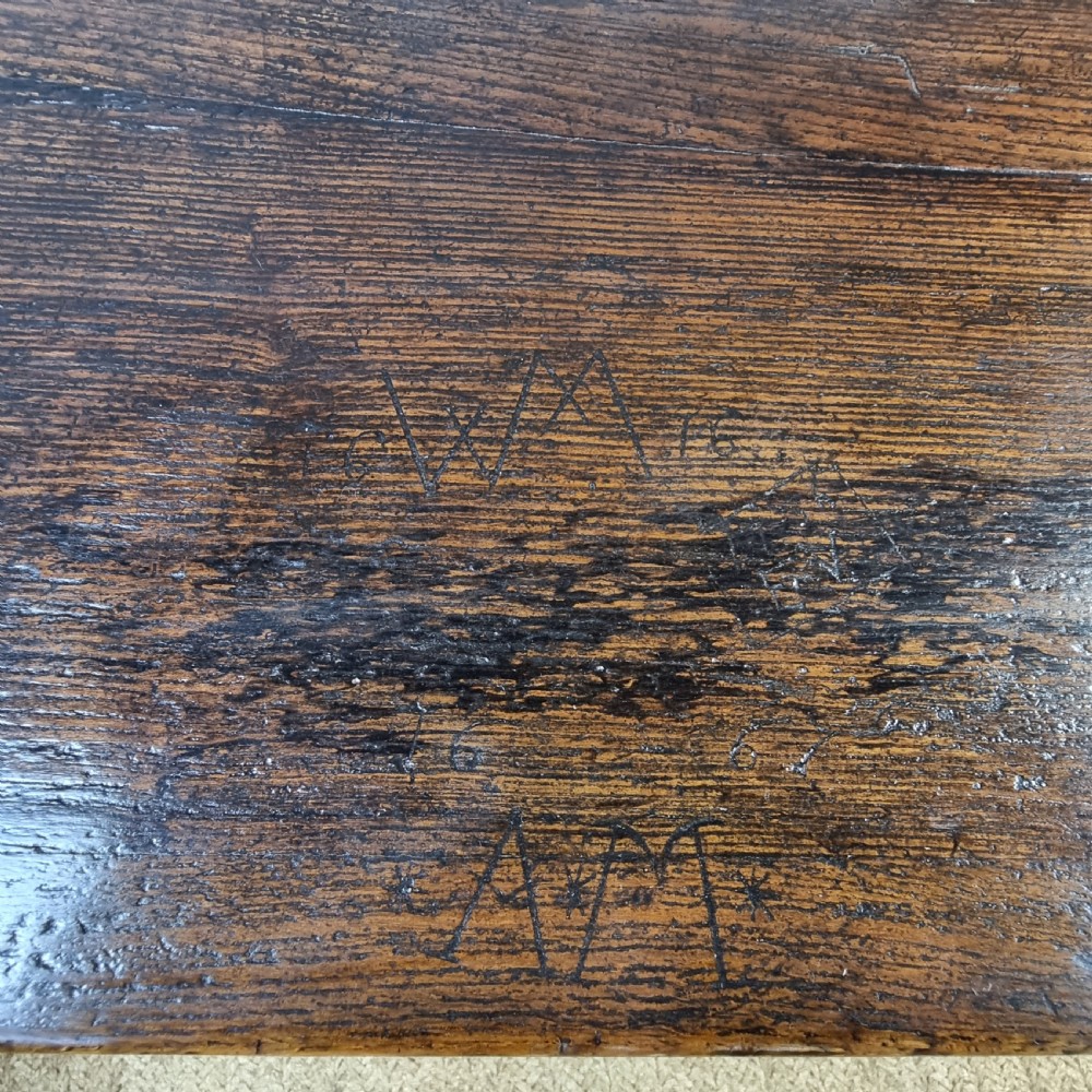 A long dark oak 17th century refectory table featuring a carved frieze along the apron, turned legs, and a sturdy low stretcher base. View XVIII