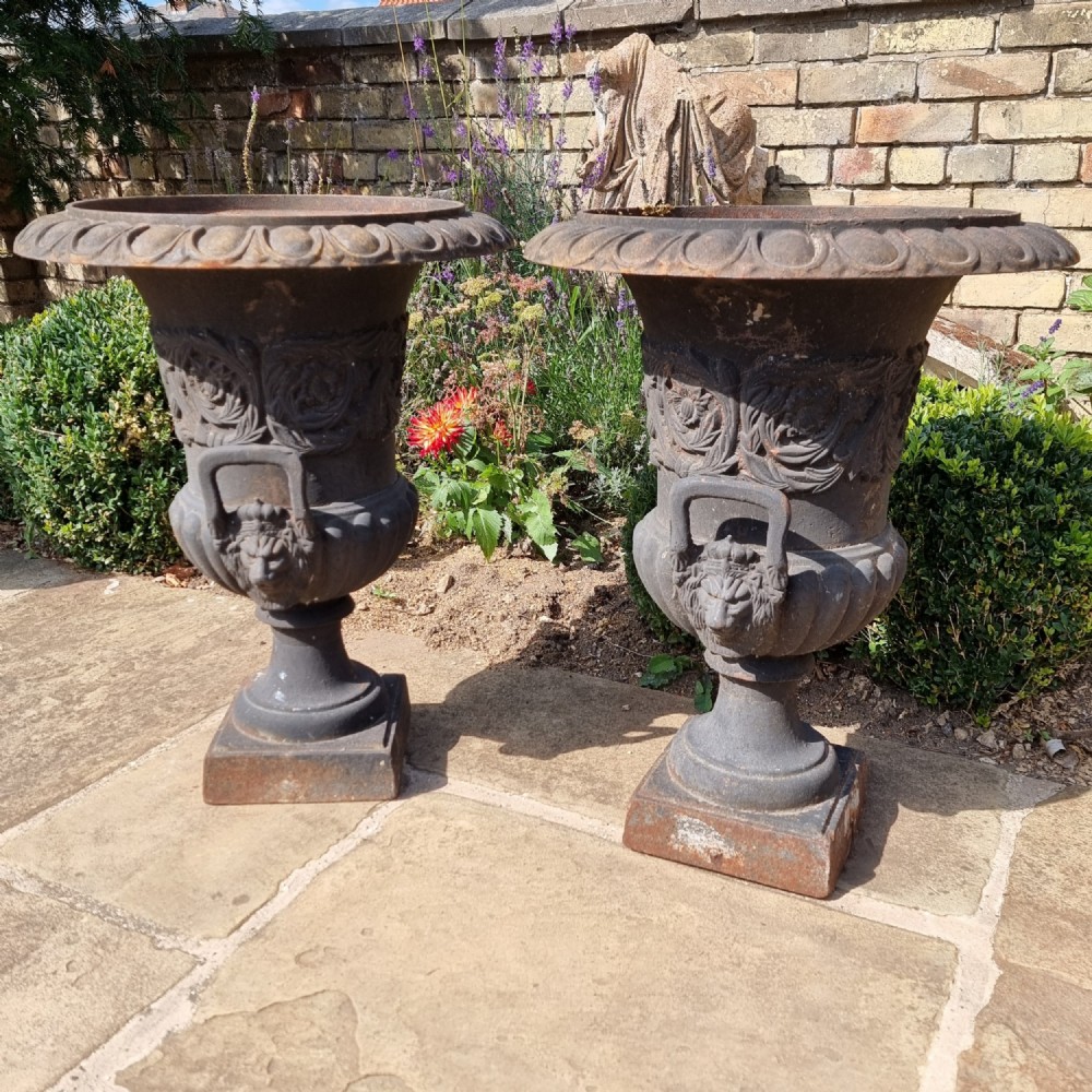 A pair of 20th century cast iron urns. 