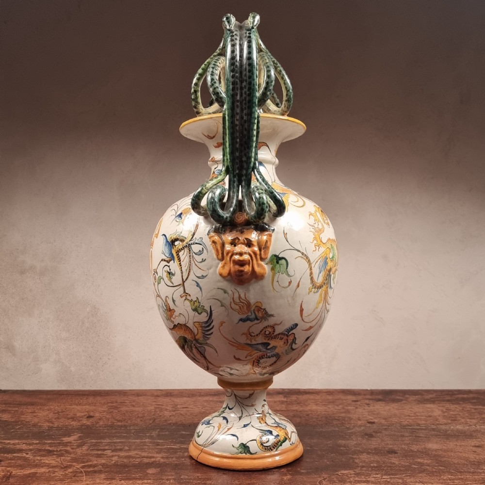A 19th-century Italian majolica urn vase featuring hand-painted mythological grotesques, a coat of arms, and twin green serpent-formed handles. View IV