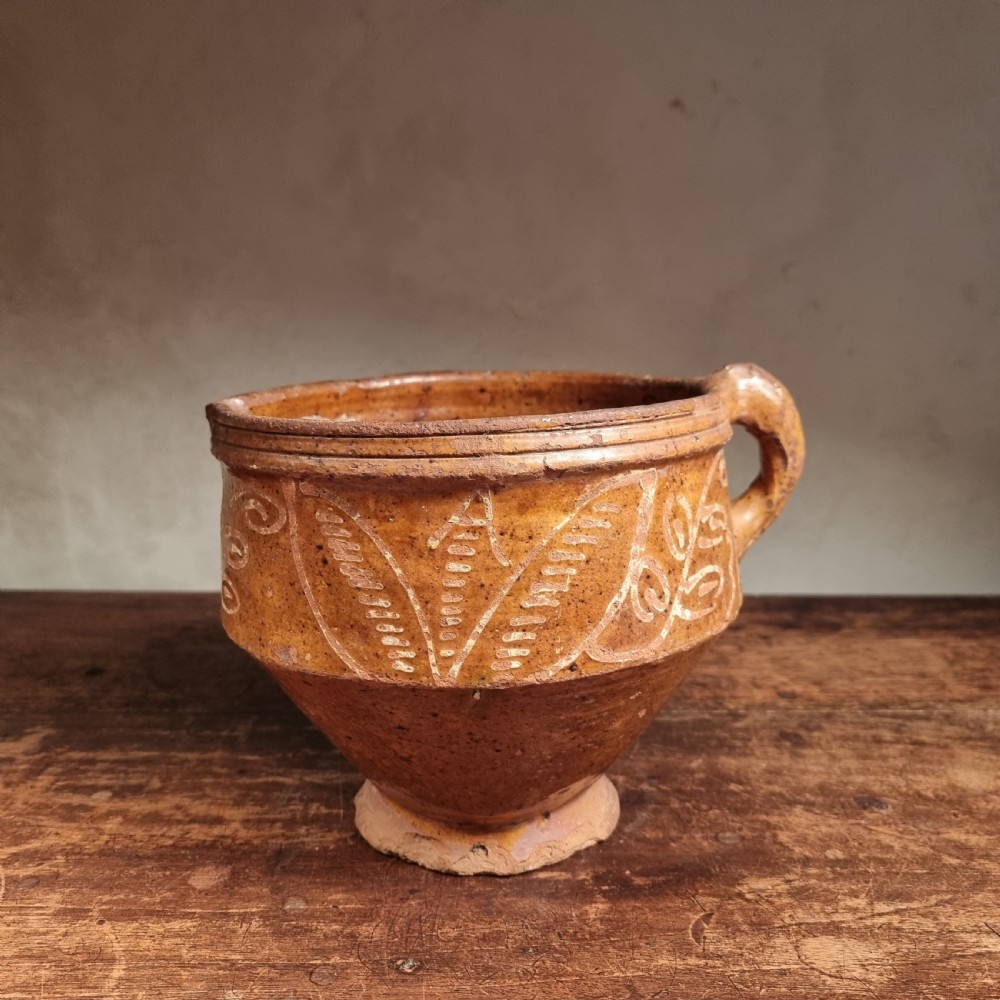 A seventeenth-century Dutch earthenware jug featuring an ochre glaze, a side loop handle, and white trailed slipware leaf patterns. View II