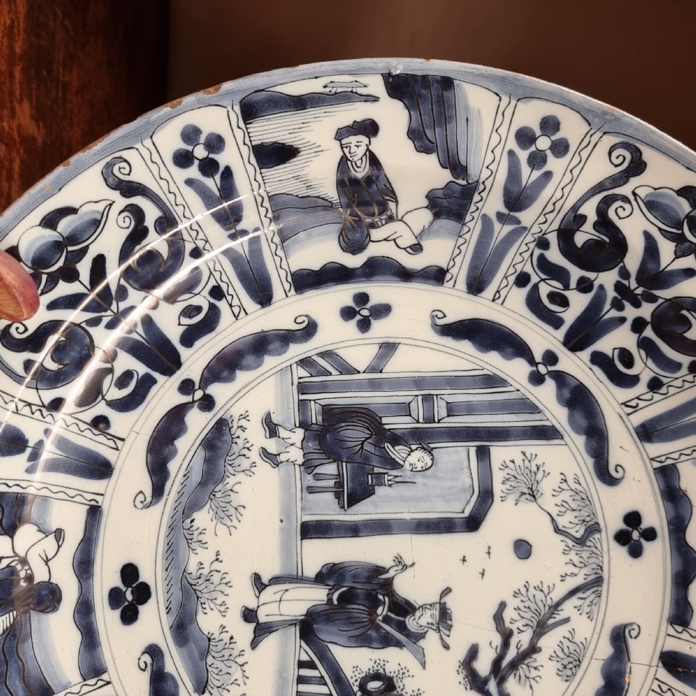 A circular seventeenth-century tin-glazed earthenware Kraak charger with cobalt blue hand-painted panels and a central figure scene. View V