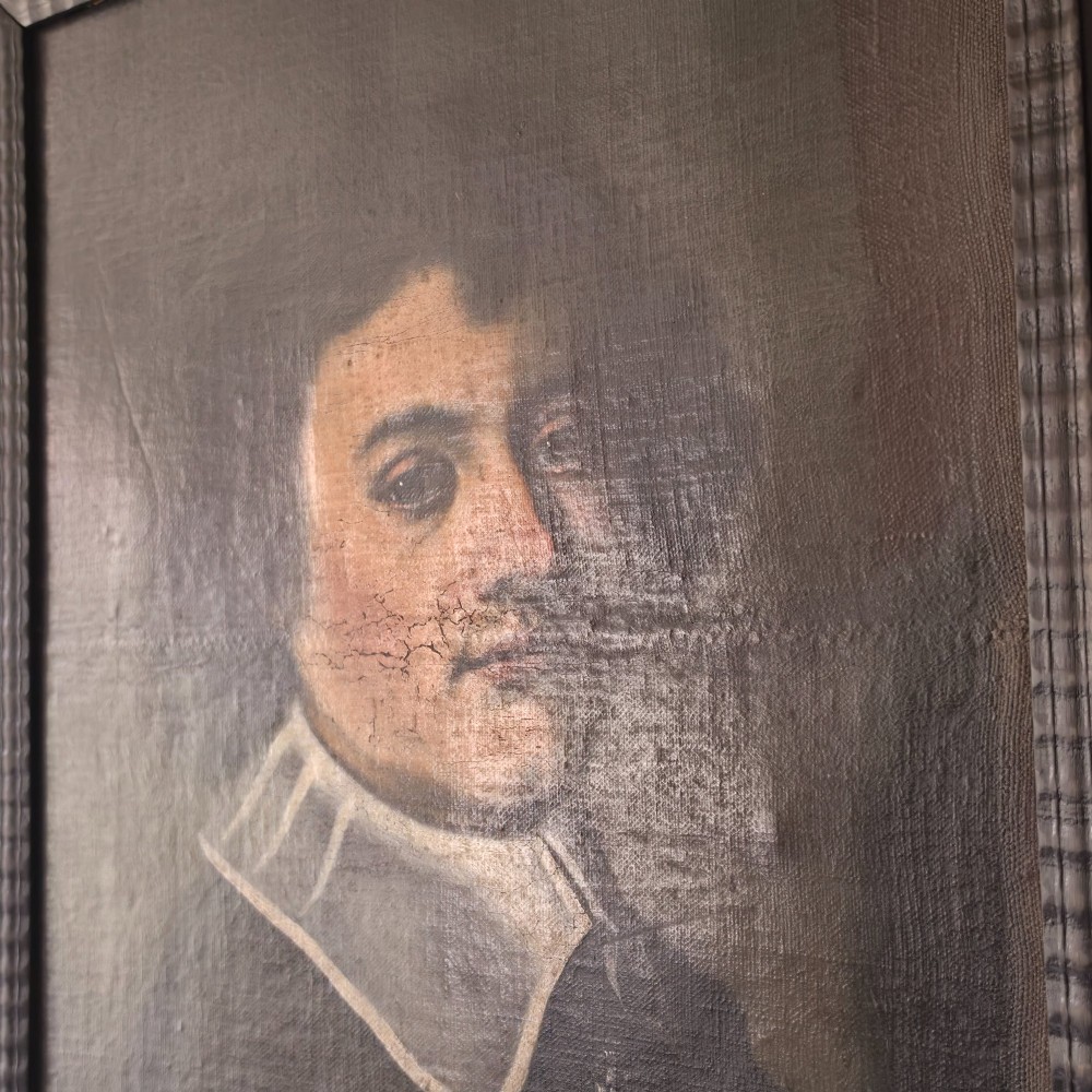 An antique oil painting depicting a 17th-century gentleman with dark hair and a white collar, presented in a dark ebonised frame. View II