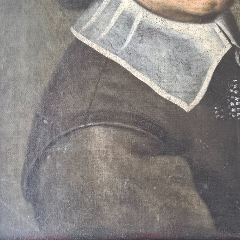An antique oil painting depicting a 17th-century gentleman with dark hair and a white collar, presented in a dark ebonised frame. View V