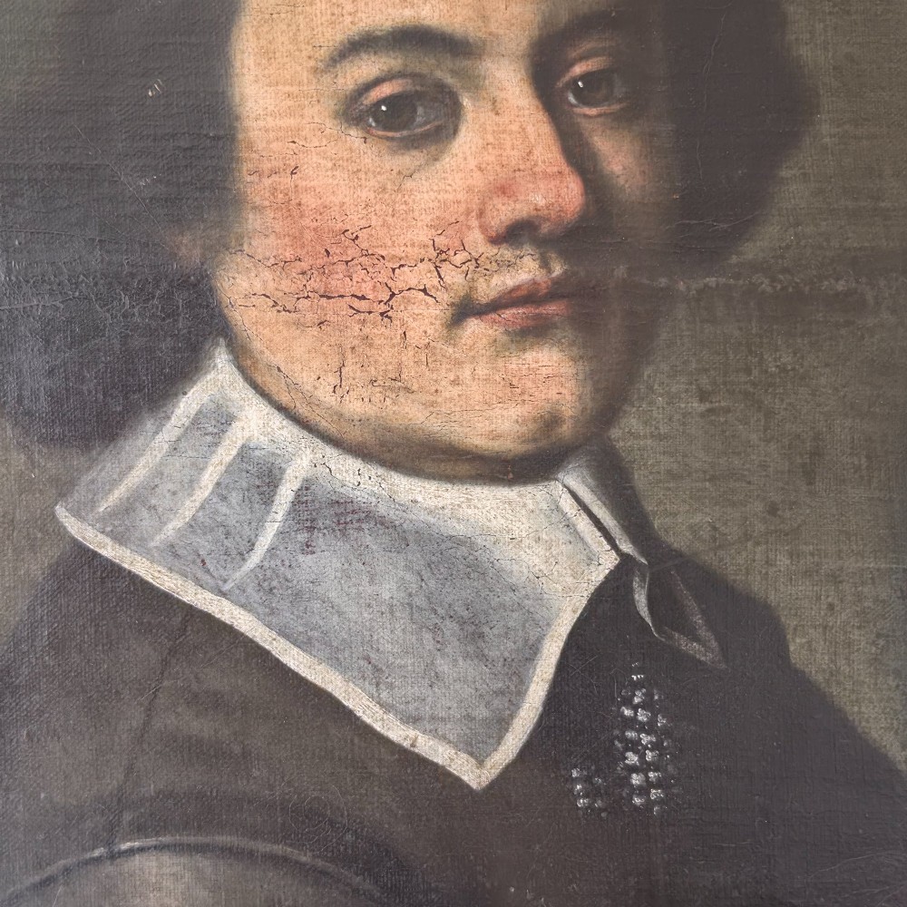 An antique oil painting depicting a 17th-century gentleman with dark hair and a white collar, presented in a dark ebonised frame. View VII