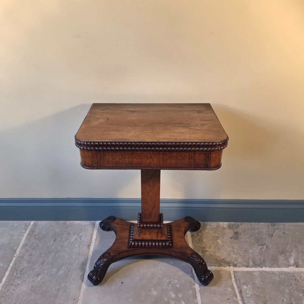 A William IV rosewood pedestal card table with a green baize playing surface, bead moulding, and carved scroll feet. View II