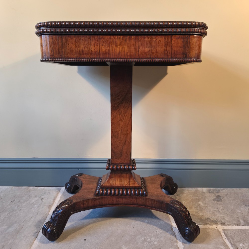 A William IV rosewood pedestal card table with a green baize playing surface, bead moulding, and carved scroll feet. View III