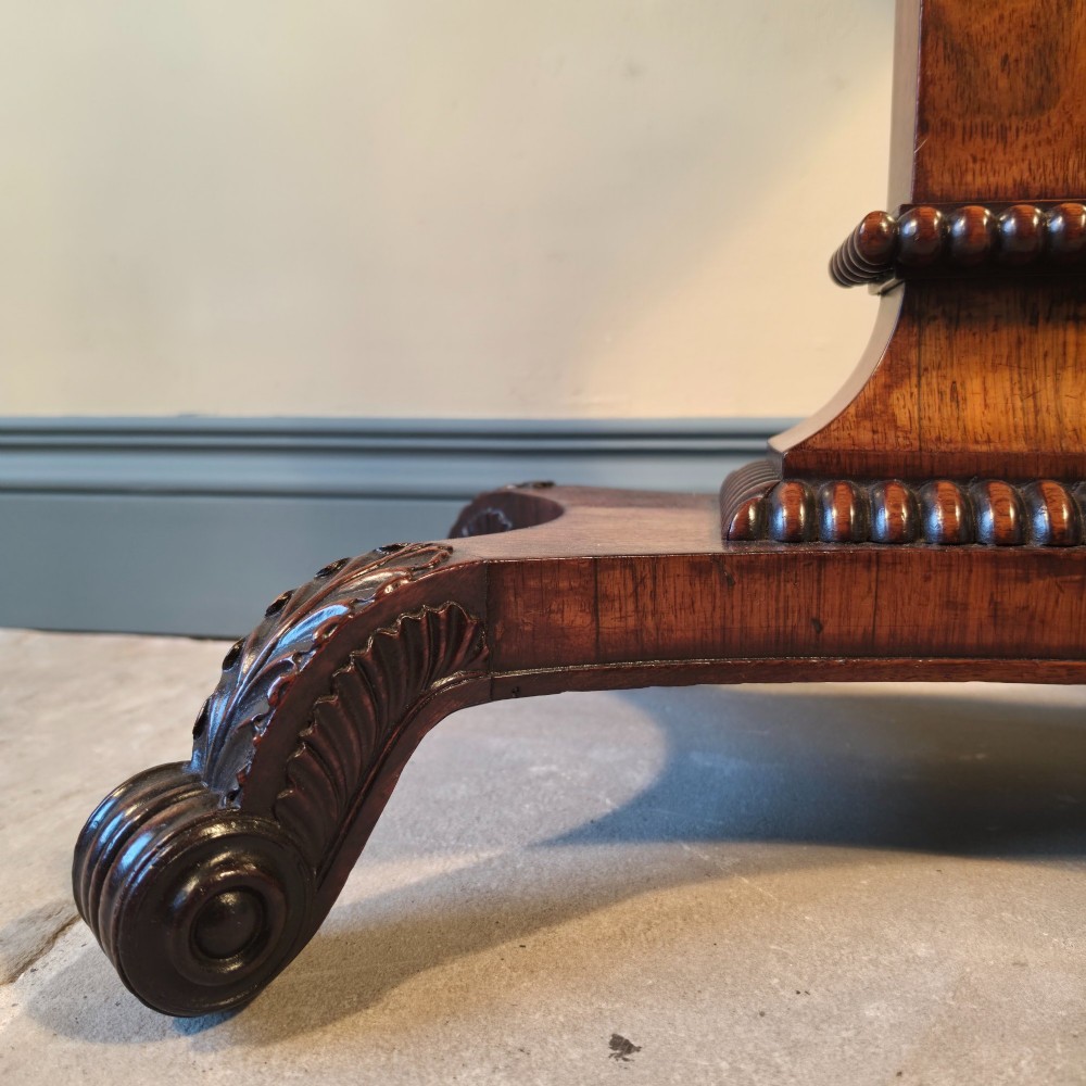 A William IV rosewood pedestal card table with a green baize playing surface, bead moulding, and carved scroll feet. View IV