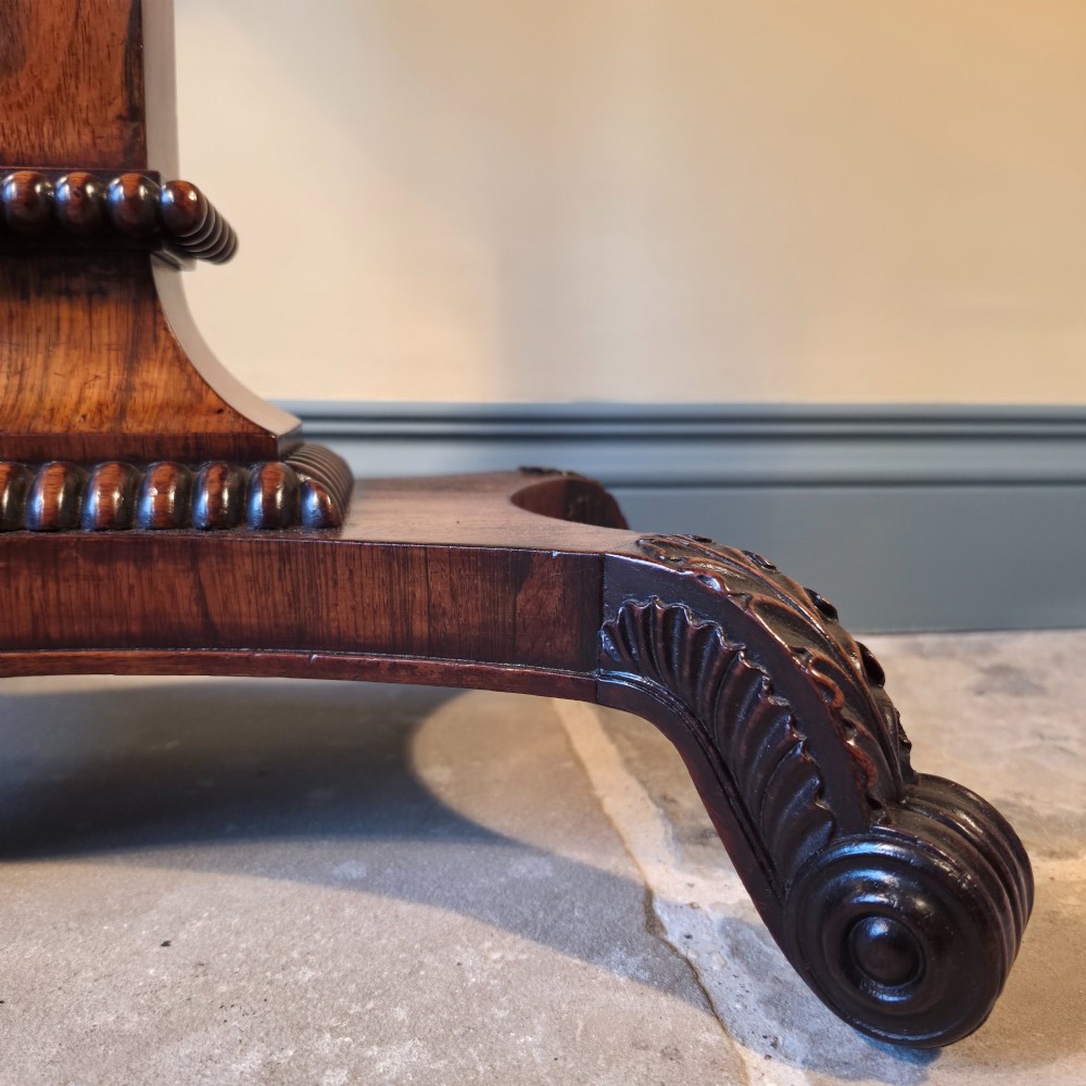 A William IV rosewood pedestal card table with a green baize playing surface, bead moulding, and carved scroll feet. View V