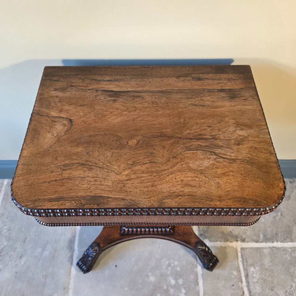 A William IV rosewood pedestal card table with a green baize playing surface, bead moulding, and carved scroll feet. View VI