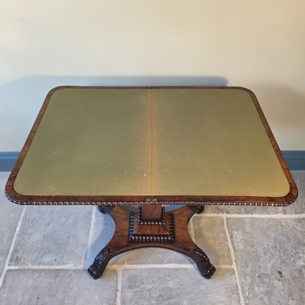 A William IV rosewood pedestal card table with a green baize playing surface, bead moulding, and carved scroll feet. View IX