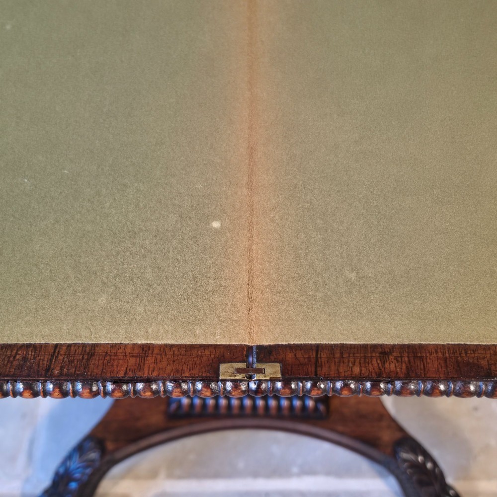 A William IV rosewood pedestal card table with a green baize playing surface, bead moulding, and carved scroll feet. View X