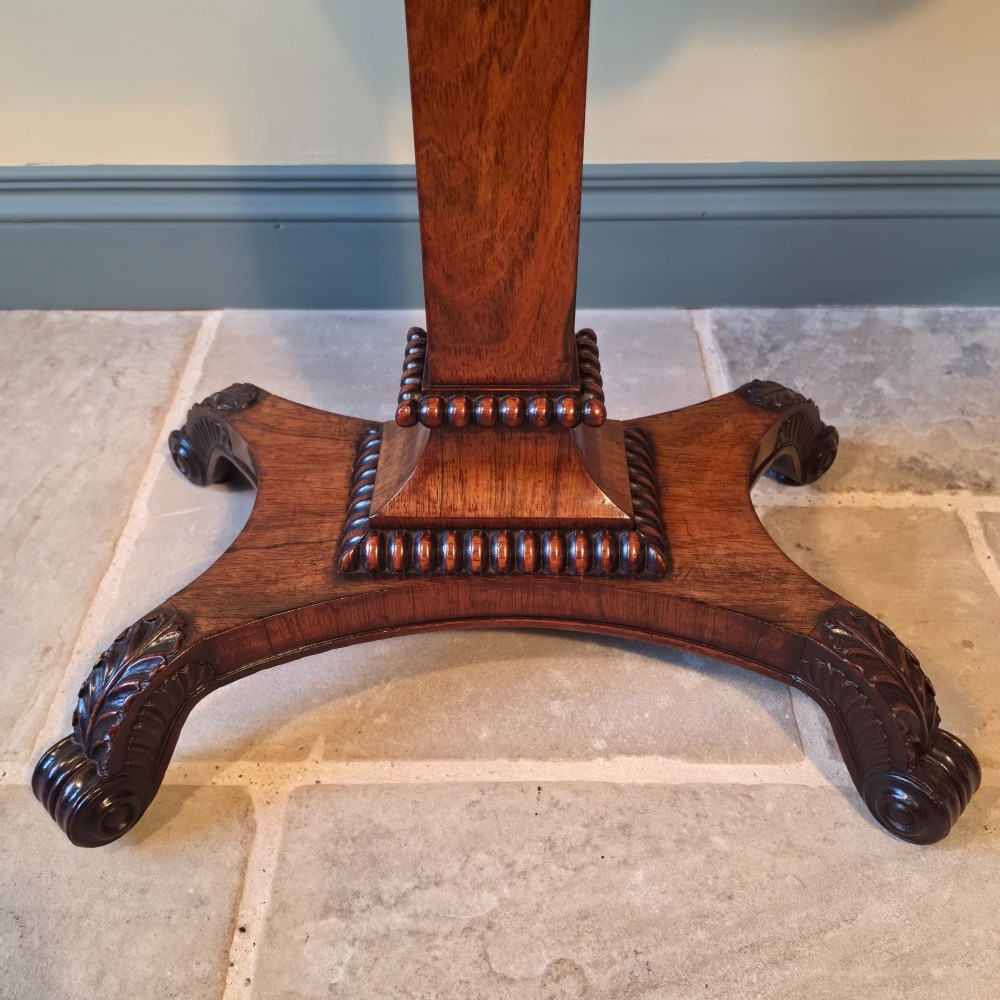 A William IV rosewood pedestal card table with a green baize playing surface, bead moulding, and carved scroll feet. View XII