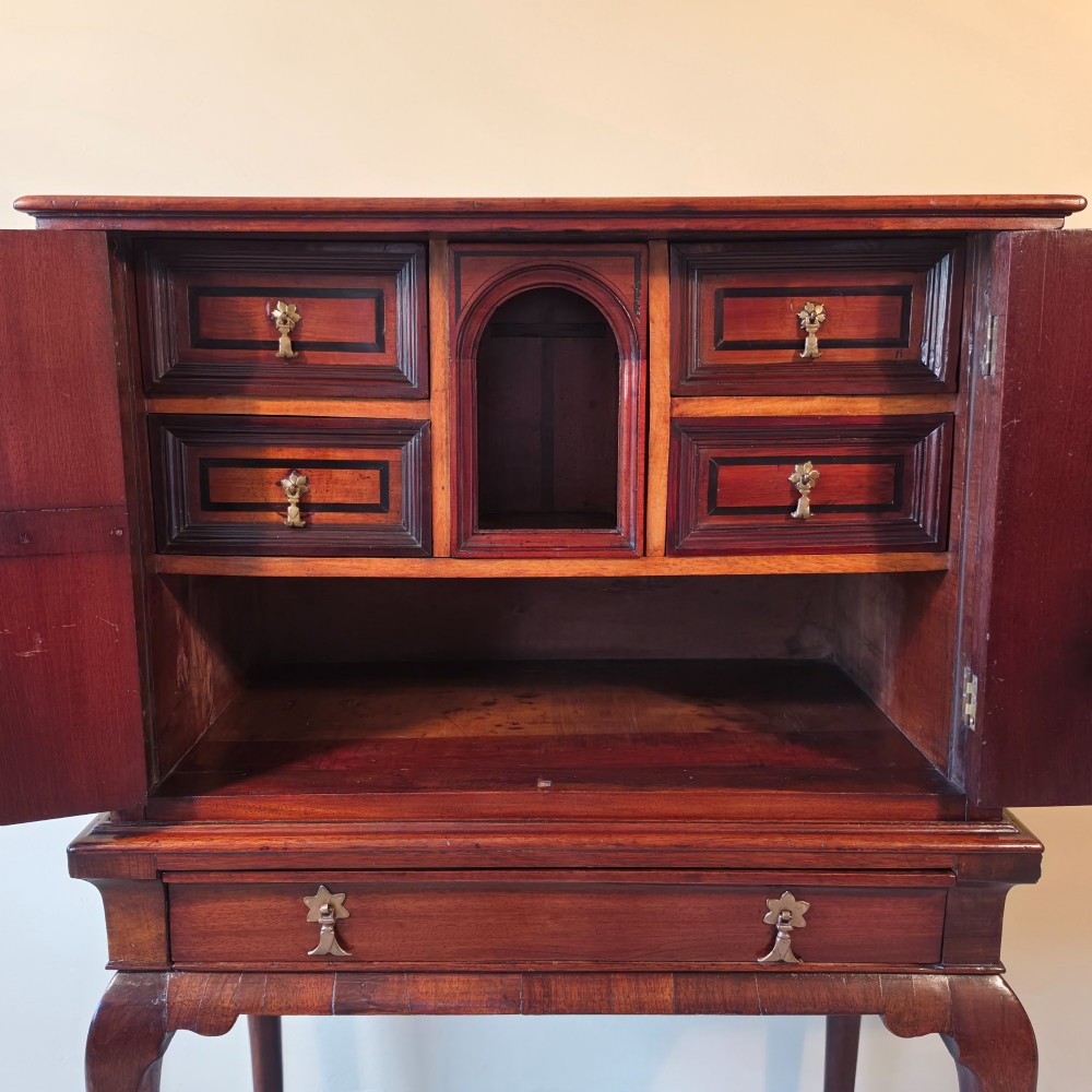 An 18th-century dark wood cabinet on stand featuring twin doors with black diamond inlay, a single lower drawer, and slender cabriole legs. View IV