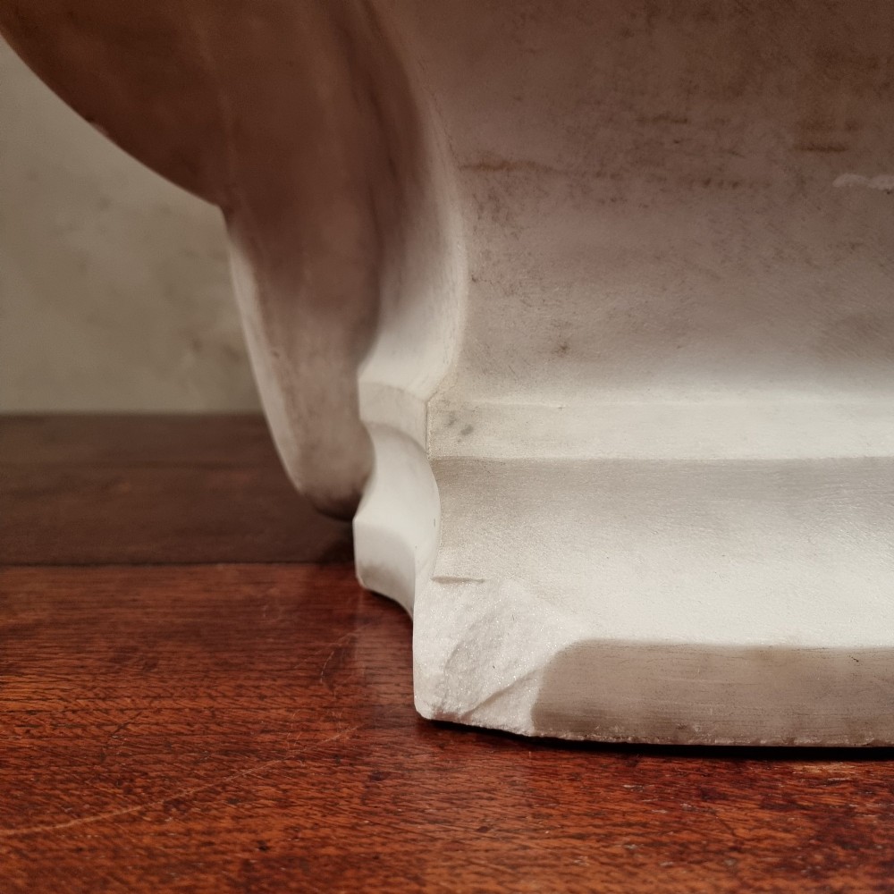 A pair of carved white marble portrait busts depicting a classical female figure on the left and a bearded man in Victorian attire on the right. View XI
