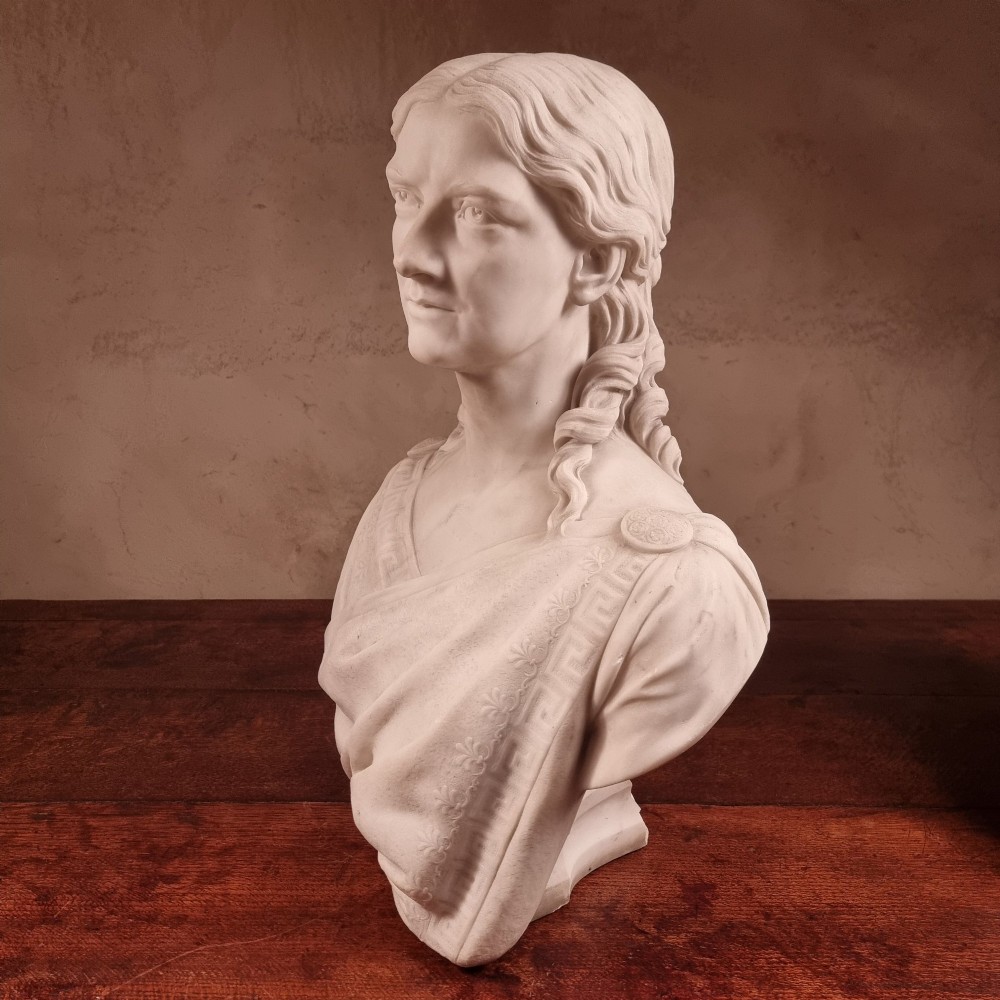 A pair of carved white marble portrait busts depicting a classical female figure on the left and a bearded man in Victorian attire on the right. View XIII