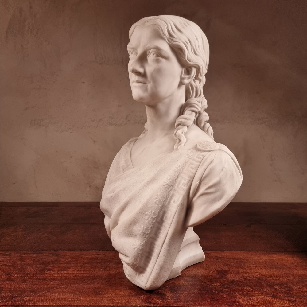 A pair of carved white marble portrait busts depicting a classical female figure on the left and a bearded man in Victorian attire on the right. View XIV