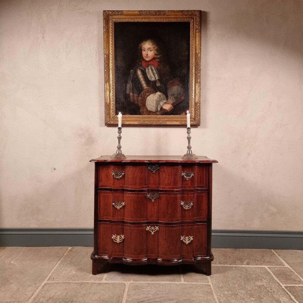 An 18th-century dark mahogany serpentine chest of drawers featuring three horizontal drawers with decorative brass handles. View II