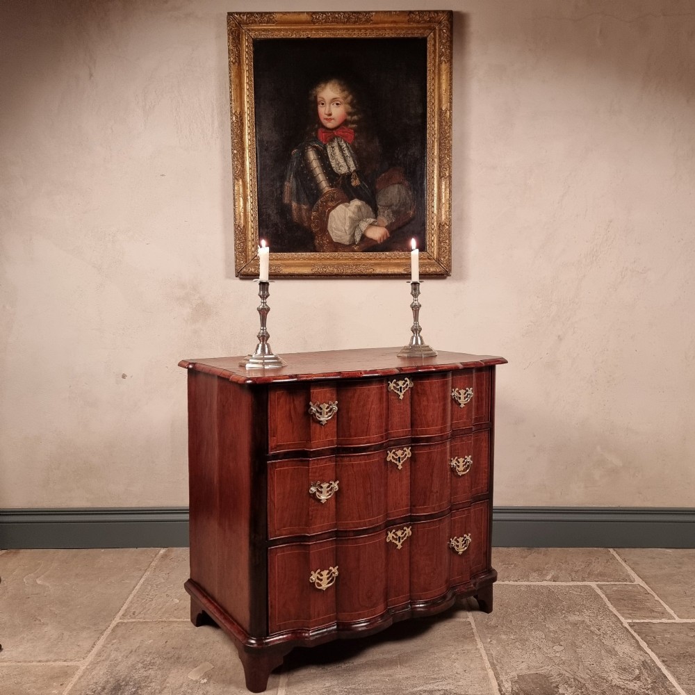 An 18th-century dark mahogany serpentine chest of drawers featuring three horizontal drawers with decorative brass handles. View VII