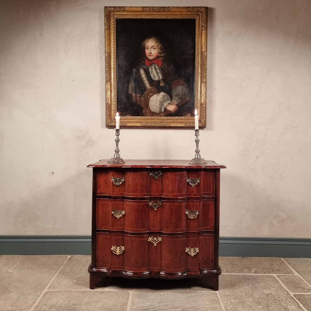 An 18th-century dark mahogany serpentine chest of drawers featuring three horizontal drawers with decorative brass handles. View VIII