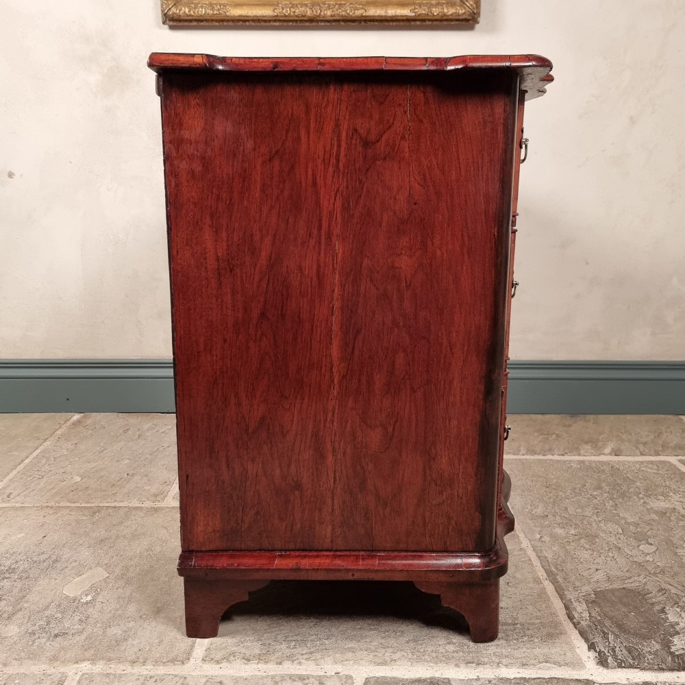 An 18th-century dark mahogany serpentine chest of drawers featuring three horizontal drawers with decorative brass handles. View XI