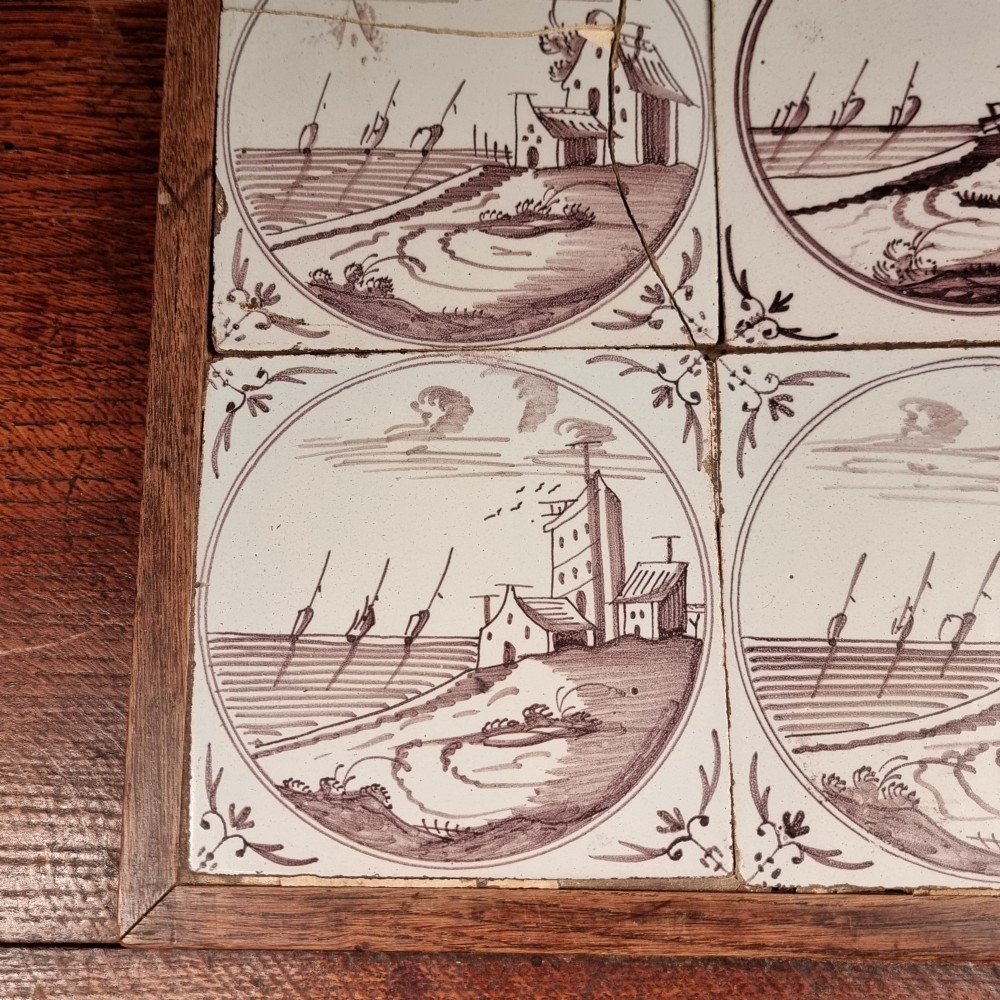 Ten eighteenth-century manganese delft tiles with hand-painted coastal landscapes set in circular reserves, mounted in two wooden frames. View III