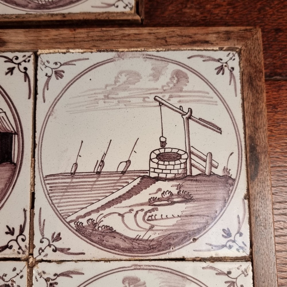 Ten eighteenth-century manganese delft tiles with hand-painted coastal landscapes set in circular reserves, mounted in two wooden frames. View VI