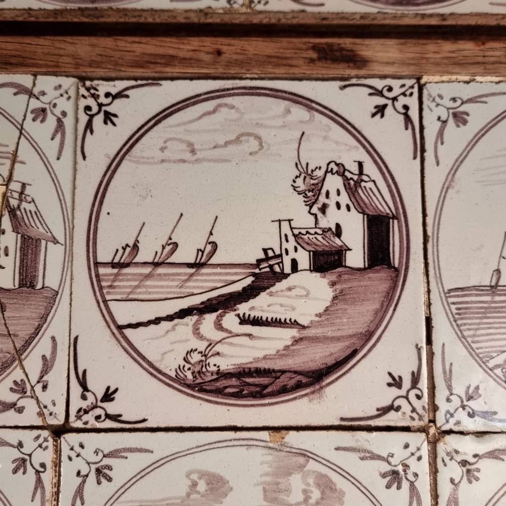 Ten eighteenth-century manganese delft tiles with hand-painted coastal landscapes set in circular reserves, mounted in two wooden frames. View VII