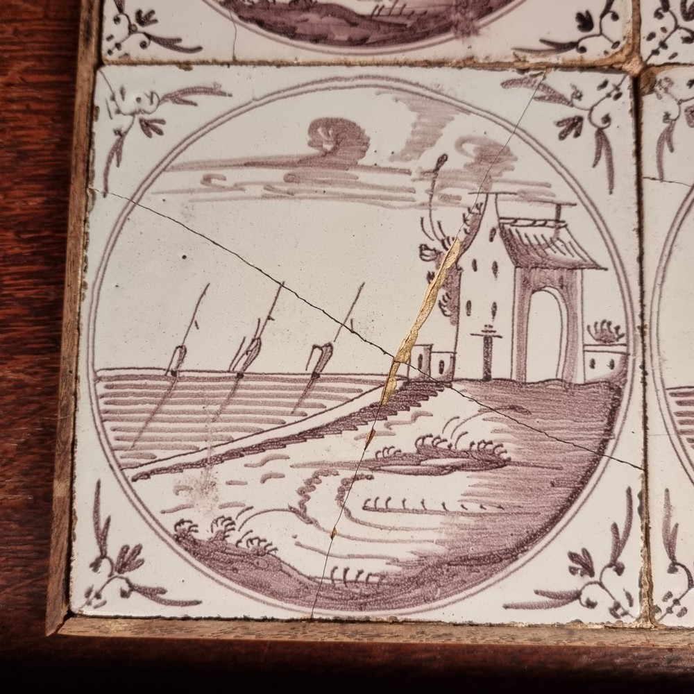 Ten eighteenth-century manganese delft tiles with hand-painted coastal landscapes set in circular reserves, mounted in two wooden frames. View VIII