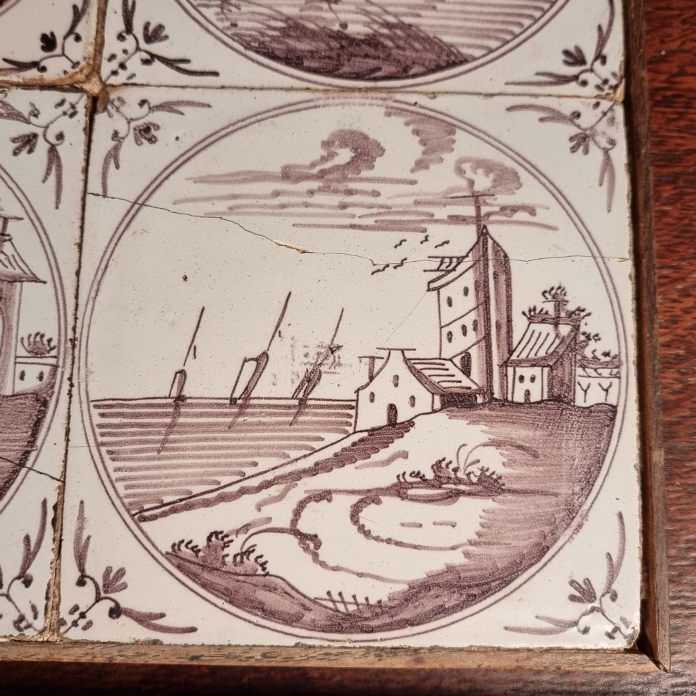 Ten eighteenth-century manganese delft tiles with hand-painted coastal landscapes set in circular reserves, mounted in two wooden frames. View IX