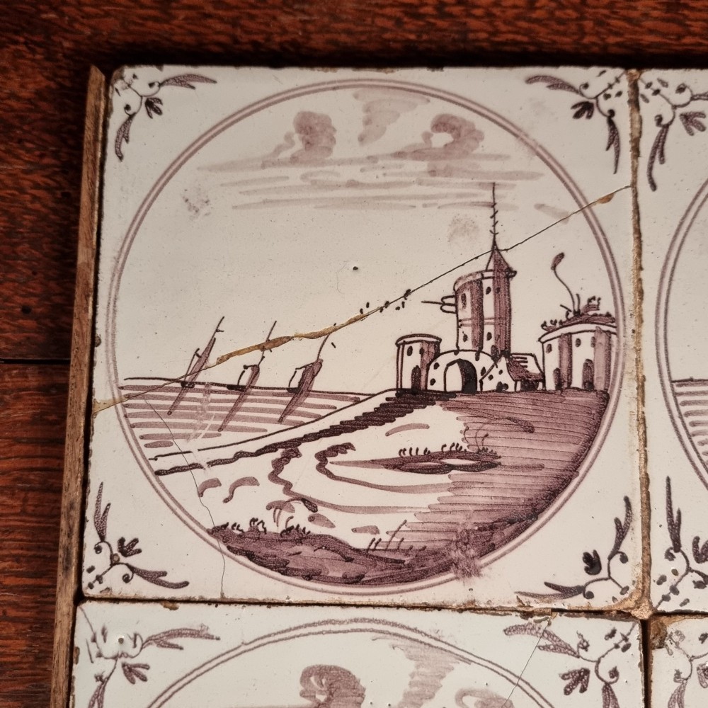 Ten eighteenth-century manganese delft tiles with hand-painted coastal landscapes set in circular reserves, mounted in two wooden frames. View XI
