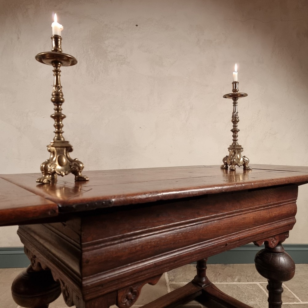 A dark oak seventeenth-century refectory dining table with extensible draw leaves, bulbous turned legs, and a floor-level perimeter stretcher. View III