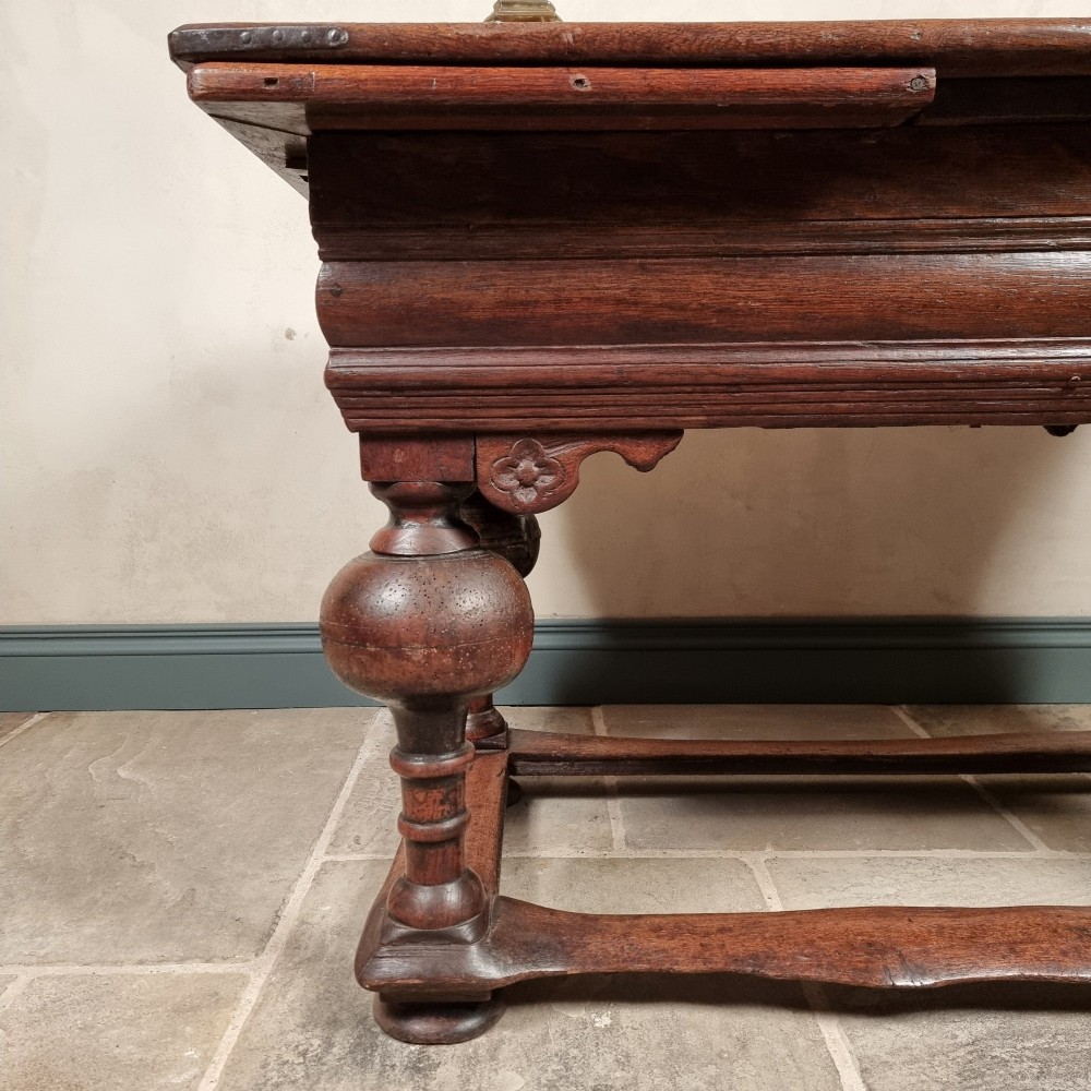 A dark oak seventeenth-century refectory dining table with extensible draw leaves, bulbous turned legs, and a floor-level perimeter stretcher. View VI
