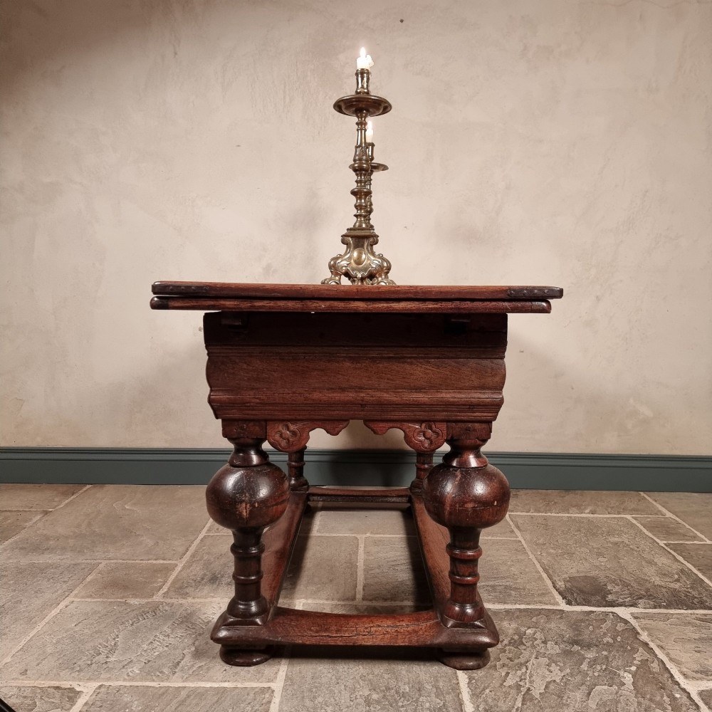 A dark oak seventeenth-century refectory dining table with extensible draw leaves, bulbous turned legs, and a floor-level perimeter stretcher. View VIII