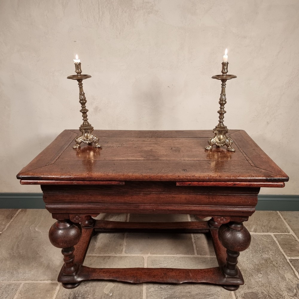 A dark oak seventeenth-century refectory dining table with extensible draw leaves, bulbous turned legs, and a floor-level perimeter stretcher. View XIII