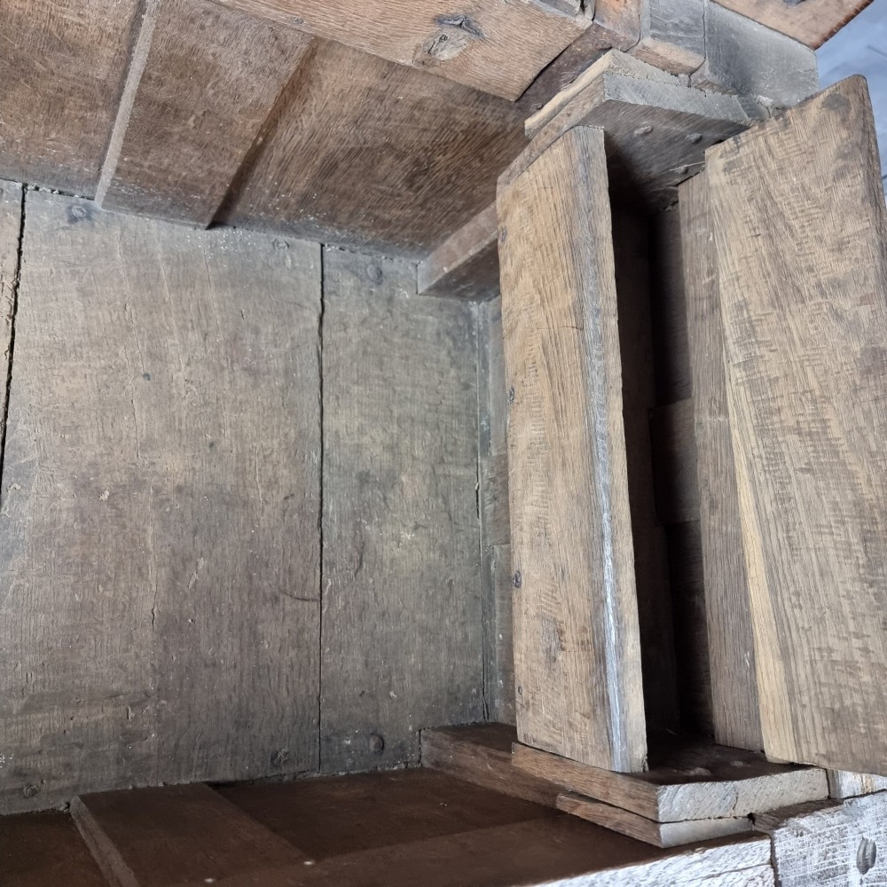 A late Elizabethan dark oak coffer with a rectangular hinged lid, iron lockplate, and panelled front facade. View XV