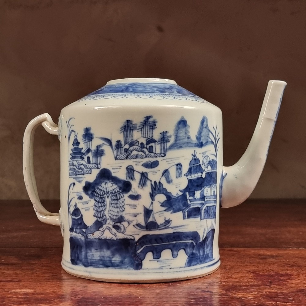 A cylindrical late 18th-century Chinese export porcelain teapot decorated with hand-painted blue and white underglaze river landscape scenes.