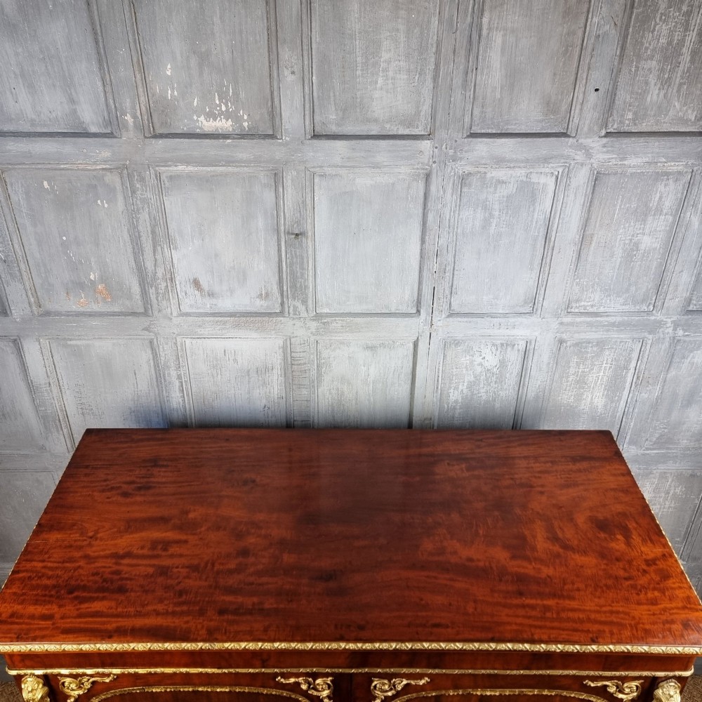 A 19th-century flame mahogany enclosed chest featuring twin doors framed with gilded metal moulding and corner mounts. View IX
