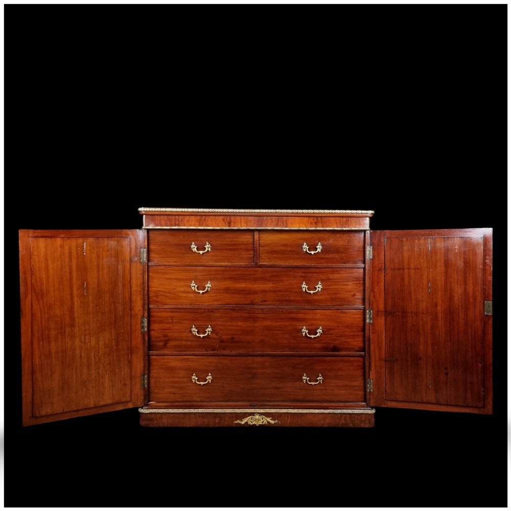 A 19th-century flame mahogany enclosed chest featuring twin doors framed with gilded metal moulding and corner mounts. View XV
