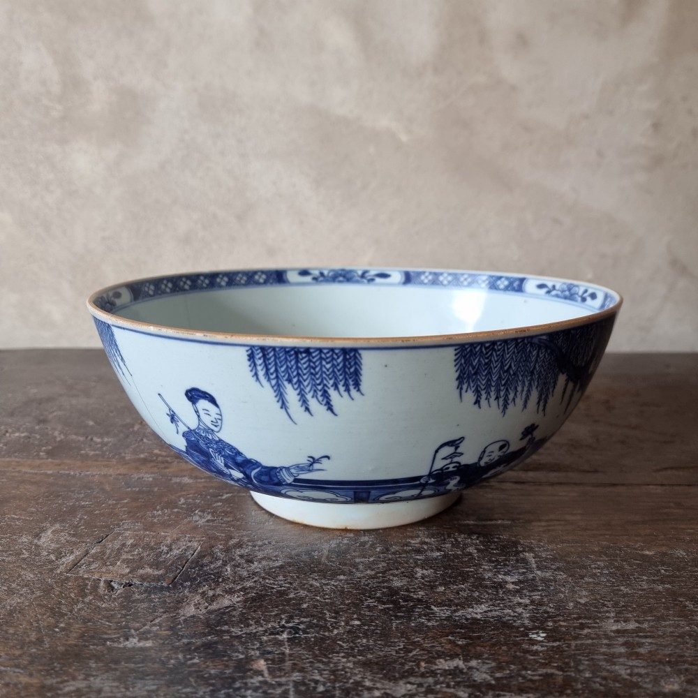 An 18th-century circular Chinese export porcelain punch bowl decorated with hand-painted blue figures under a willow tree. View II