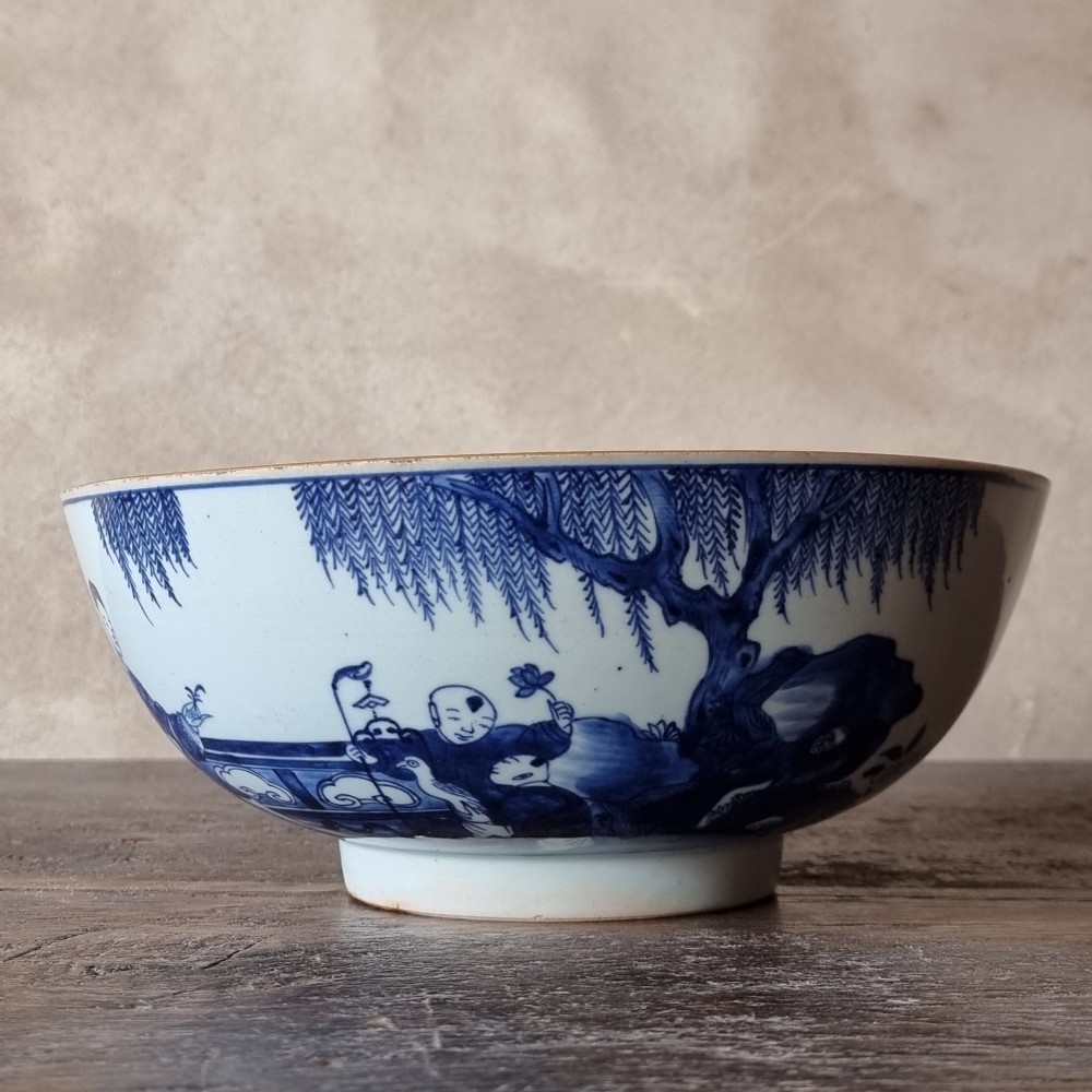 An 18th-century circular Chinese export porcelain punch bowl decorated with hand-painted blue figures under a willow tree. View III