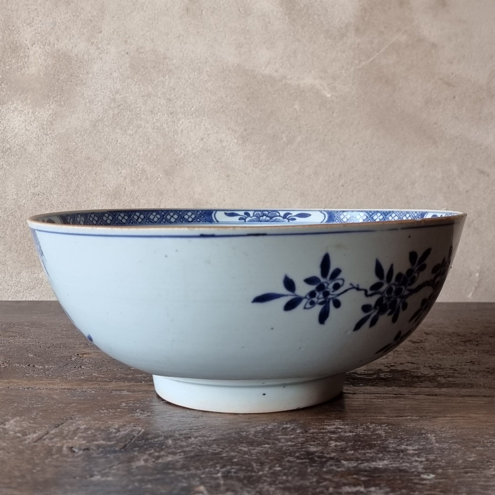 An 18th-century circular Chinese export porcelain punch bowl decorated with hand-painted blue figures under a willow tree. View V